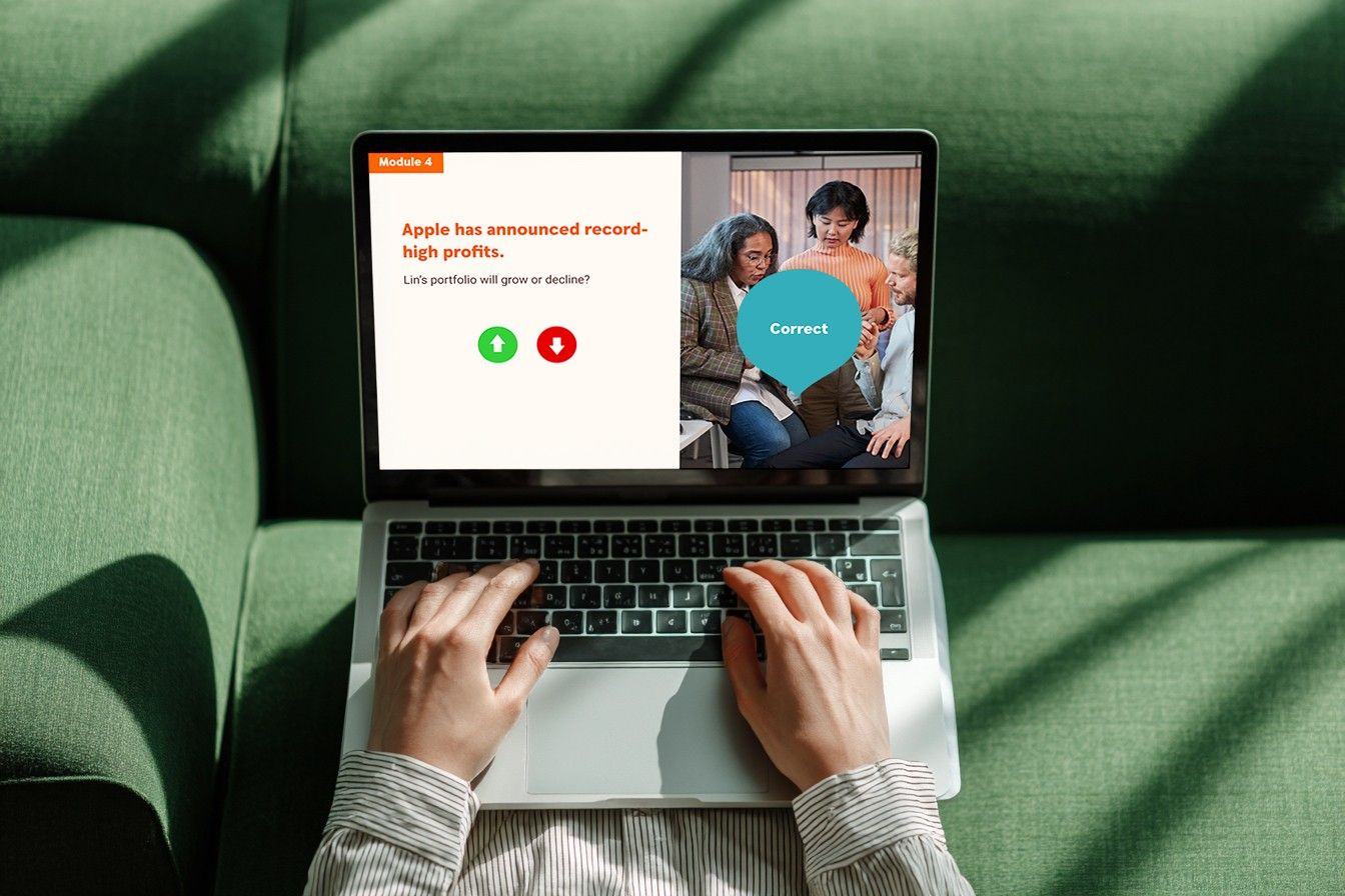 Overhead view of a person completing a financial quiz on a laptop while seated on a green sofa.